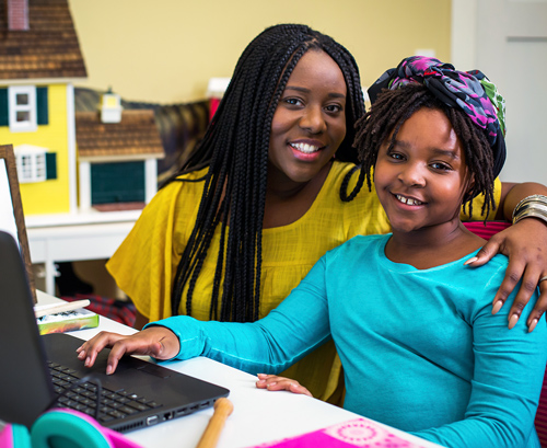 Mother and daughter working on their laptop